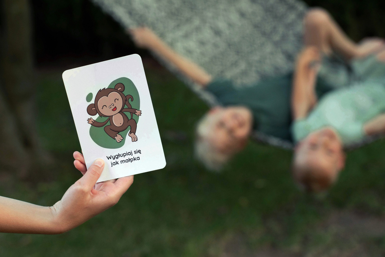 dziecko bawi się kartami aktywności na spacerze